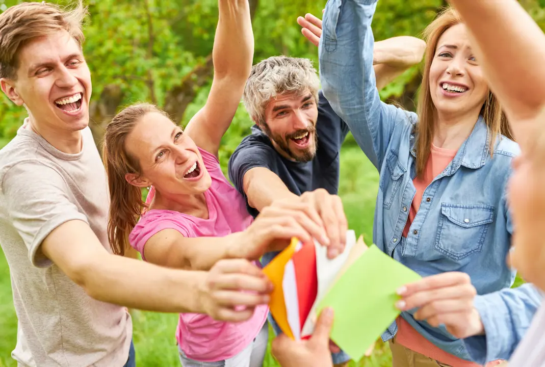 Groupe d'amis jouant à un jeu d'équipe en extérieur.
